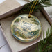 A decorative ornament in a box, featuring a scenic image of Catawba Island, State Park, and Ohio.