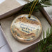 A decorative ornament in a box, featuring a scenic image of the Cathedral Gorge State Park in Nevada.