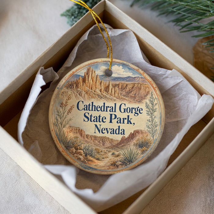 A decorative ornament in a box, featuring an illustration of the Cathedral Gorge State Park in Nevada.