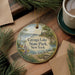 A decorative ornament featuring a scenic image of Cayuga Lake State Park in New York, surrounded by pine branches and a cup of coffee on a wooden surface.