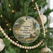 A round ornament hanging on a Christmas tree, featuring a scenic illustration of a river, a wagon, and a cabin, with the text "Chapog State Heritage Area, Oregon" displayed on it.
