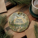 A round ornament with a scenic image of Cheraw State Park, South Carolina, hanging on a wooden surface.