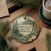 A decorative ornament featuring a scenic landscape of Chief Timothy State Park in Washington, surrounded by pine branches and a cup of coffee on a wooden surface.