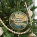 A round ornament hanging on a Christmas tree, featuring a scenic image of Clayton Lake State Park in Oklahoma.