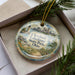 A decorative ornament featuring a scenic view of Cleveland Lakefront State Park, Ohio, with a lighthouse and a city skyline in the background.