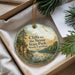 A round ornament with a scenic landscape of cliffs, trees, and a river, hanging from a string.
