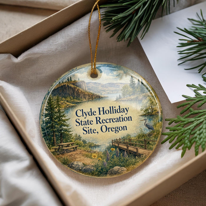 A round ornament with a scenic landscape of a park and a bird, hanging from a string.