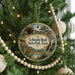 A round ornament hanging on a Christmas tree, featuring a scenic image of Colorado Bend State Park, Texas.