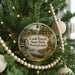 A round ornament hanging on a Christmas tree, featuring a scenic image of Cook Forest State Park, Pennsylvania.