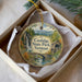 A decorative ornament in a box, featuring a scenic image of Coolidge State Park in Vermont.