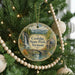 A circular ornament hanging on a Christmas tree, featuring a scenic image of Coolidge State Park in Vermont.