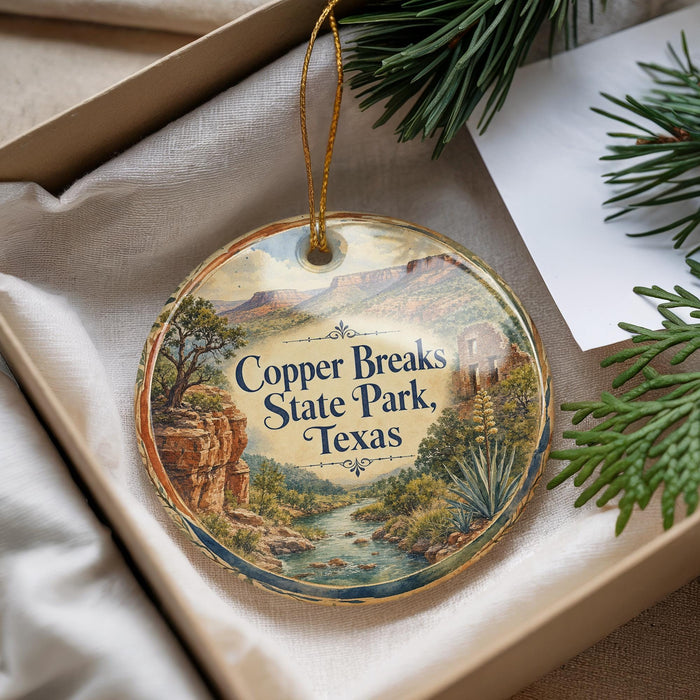A decorative ornament with a scenic landscape of Copper Breaks State Park, Texas, featuring a river, mountains, and desert vegetation.