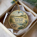 A decorative ornament in a box, featuring a lighthouse and a seashore scene, with the text "Corson's Inlet State Park, New Jersey" printed on it.