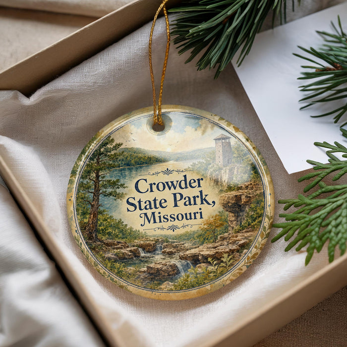 A decorative ornament with a scenic landscape of a river, mountains, and greenery, featuring the text "Crowder State Park, Missouri" on it.