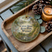 A decorative ornament featuring a scenic image of the Cuivre River State Park in Missouri, with a candle and pine cones on a wooden tray.