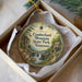 A decorative ornament in a box, featuring a scenic landscape with a waterfall and a small building, likely representing Cumberland Mountain State Park in Tennessee.