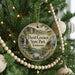 A Christmas tree decorated with ornaments, including a circular ornament with a scenic image of David Crockett State Park, Tennessee.