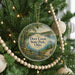 A round ornament hanging on a Christmas tree, featuring a scenic image of Deer Creek State Park, Ohio.