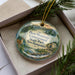 A decorative ornament in a box, featuring a scenic landscape with a deer, trees, and a tent, along with the text "Deer Mountain Campground State Park, New Hampshire".