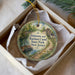 A decorative ornament in a box, featuring a scenic image of the Delaware and Raritan Canal State Park in New Jersey.