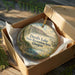 A wooden box containing a decorative ornament with a scenic landscape of Devil's Lake State Recreation Area, Oregon.