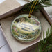 A decorative ornament in a box, featuring a scenic image of the Dillard Mill State Historic Site in Missouri.