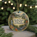 A decorative ornament featuring a scenic landscape with a waterfall, mountains, and pine trees, hanging on a string.