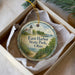 A decorative ornament in a box, featuring a lighthouse and a scenic landscape, with the text "East Harbor State Park, Ohio" printed on it.