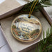 A decorative ornament in a box, featuring a scenic landscape of Echo Canyon State Park, Nevada.