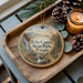 A wooden tray with a decorative ornament featuring a scenic image of Echo Canyon State Park, Nevada, along with pine cones and a lit candle.