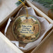 A round ornament with a picture of a cedar forest and a sign that says "Edge of the Cedars State Park Museum, Utah".