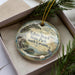 A decorative ornament in a box, featuring a scenic image of Edisto Beach State Park in South Carolina.