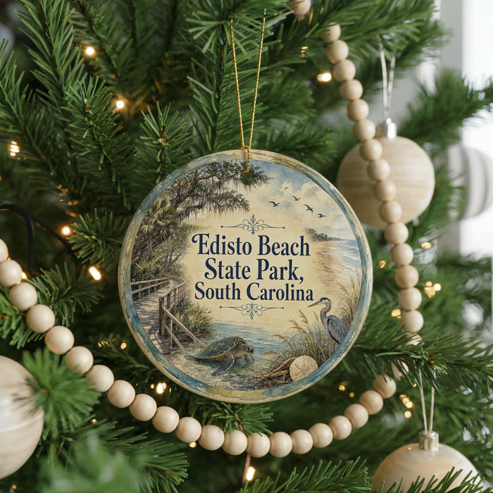 A round ornament hanging on a Christmas tree, featuring a scenic image of Edisto Beach State Park, South Carolina.