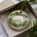 A decorative ornament in a box, featuring a scenic image of Pennsylvania State Park.