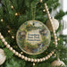 A round ornament hanging on a Christmas tree, featuring a scenic image of Pennsylvania State Park.