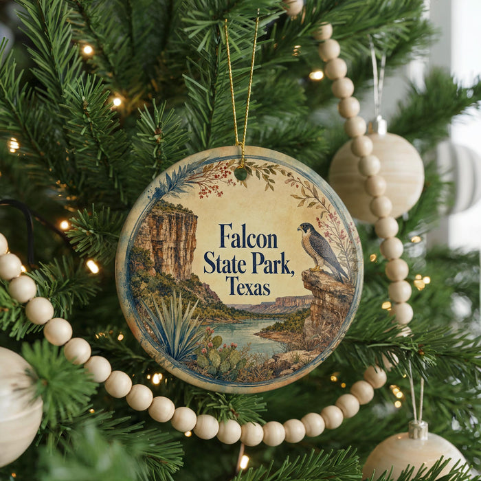 A round ornament hanging on a Christmas tree, featuring a scenic landscape of a cliff, river, and desert.