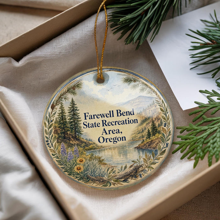 A decorative ornament with a scenic landscape and text that reads " Farewell Bend State Recreation Area, Oregon" is displayed in a box with pine branches.