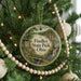 A round ornament hanging on a Christmas tree, featuring a scenic image of Findley State Park, Ohio.