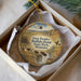 A decorative ornament in a white box, featuring a scenic landscape with buffalo and a person on horseback.