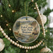A round ornament hanging on a Christmas tree, featuring a scenic image of Fish Creek State Park, Montana.