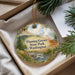 A decorative ornament with a scenic landscape of Flaming Geyser State Park, Washington, featuring a river, mountains, and pine trees.