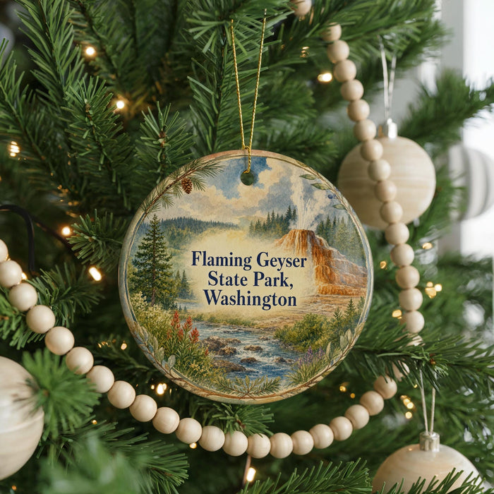 A Christmas tree decorated with ornaments, including a circular ornament with a scenic landscape of Flaming Geyser State Park, Washington.