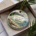 A decorative ornament in a box, featuring a scenic image of Flathead Lake State Park in Montana.