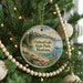 A round ornament hanging on a Christmas tree, featuring a scenic landscape of Flathead Lake State Park, Montana.