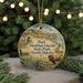 A round ornament with a picture of Fort Abraham Lincoln, State Park, and North Dakota, surrounded by pine branches and twinkling lights.