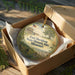 A decorative ornament in a wooden box, featuring an illustration of Fort Davidson State Historic Site in Missouri.