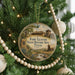 A round ornament hanging on a Christmas tree, featuring an illustration of Fort Leaton, the historic site in Texas.