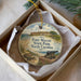 A round ornament with a painting of Fort Mason, a historic fort located in North Carolina, featuring a turtle and a cannon.