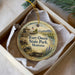 A decorative ornament in a box, featuring a scenic image of Fort Owen State Park in Montana.