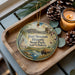 A decorative ornament featuring a scenic image of Fortissot Historic State Park, South Dakota, with a bison in the foreground and a candle in the background.